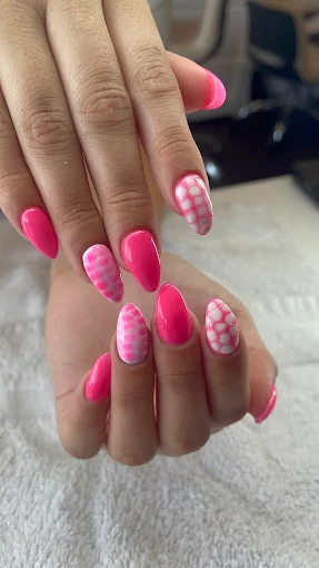 Vibrant pink nails with playful wavy art
