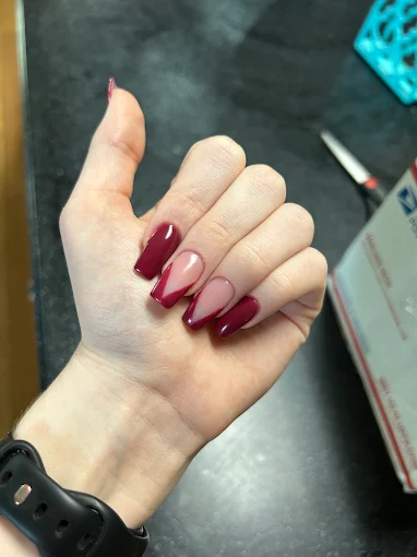Glossy burgundy stiletto nails with diagonal nude accents